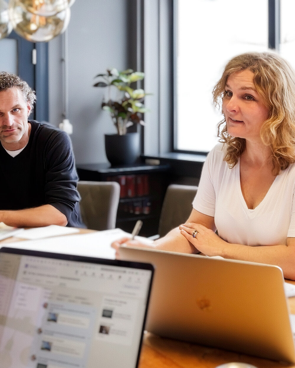 Twee mensen in gesprek aan de vergadertafel op het kantoor in Naarden